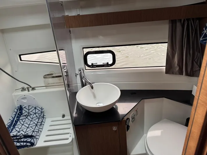  Yacht Photos Pics Modern bathroom interior of 2020 Jeanneau NC 1095 boat with sink, toilet, and window.