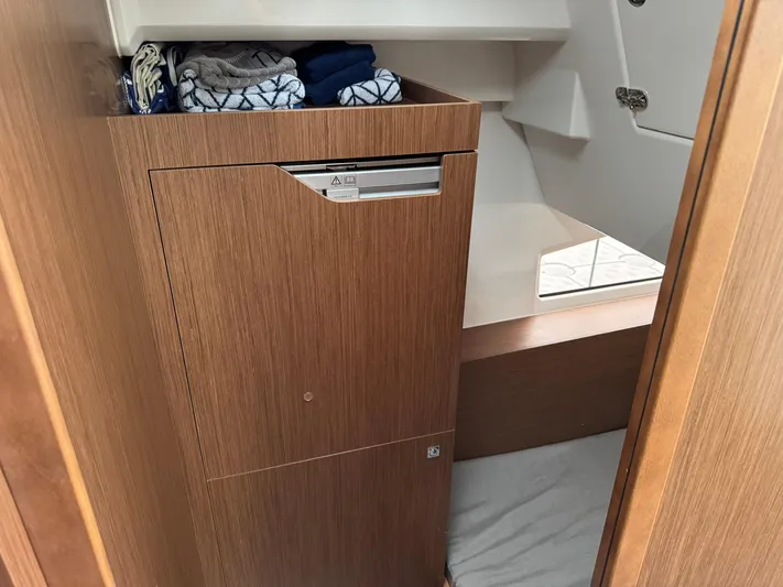  Yacht Photos Pics Interior of 2020 Jeanneau NC 1095 boat with wooden cabinetry and storage space.