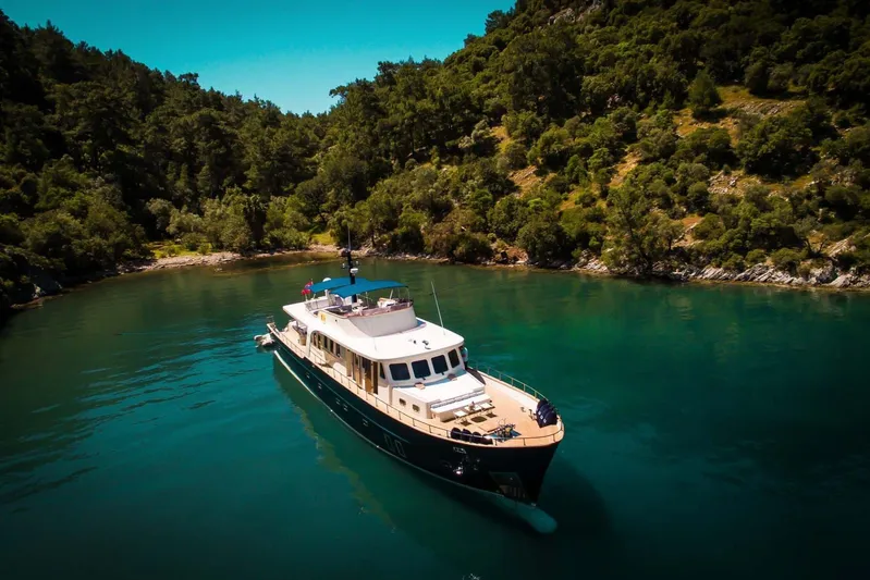 Dali Yacht Photos Pics Custom 28M yacht from 2006 cruising in a serene, forested bay.