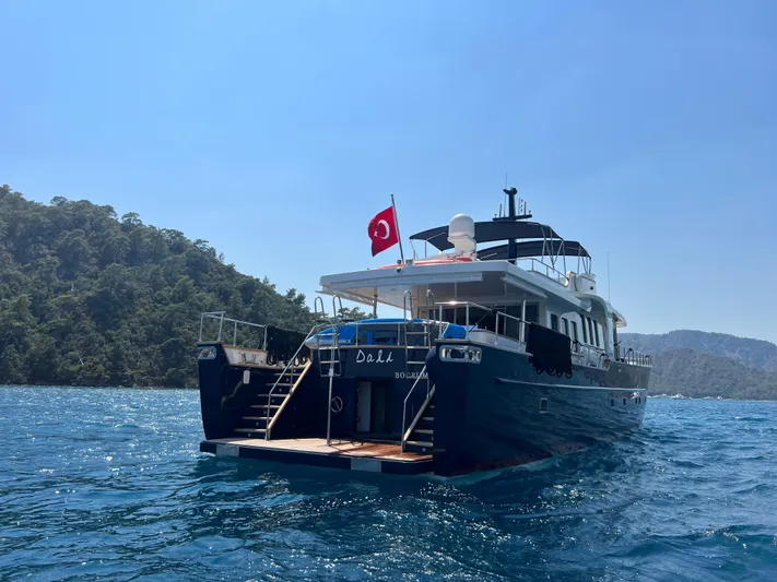 Dali Yacht Photos Pics Custom 28M yacht from 2006 on blue water, Turkish flag, scenic background.