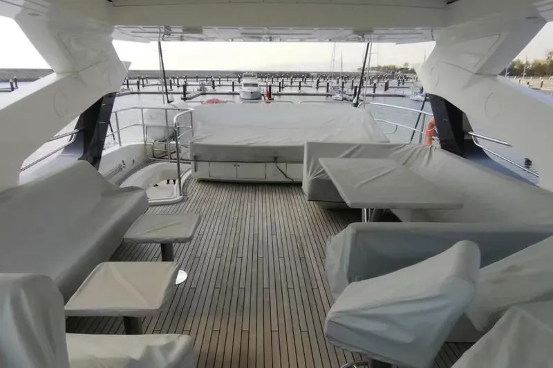  Yacht Photos Pics Sunseeker 95 Yacht 2018 deck with covered seating and table, overlooking marina.
