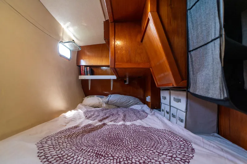 See The World Yacht Photos Pics Cozy cabin interior with wooden storage, bed, and soft lighting in a 1998 Custom model 49.