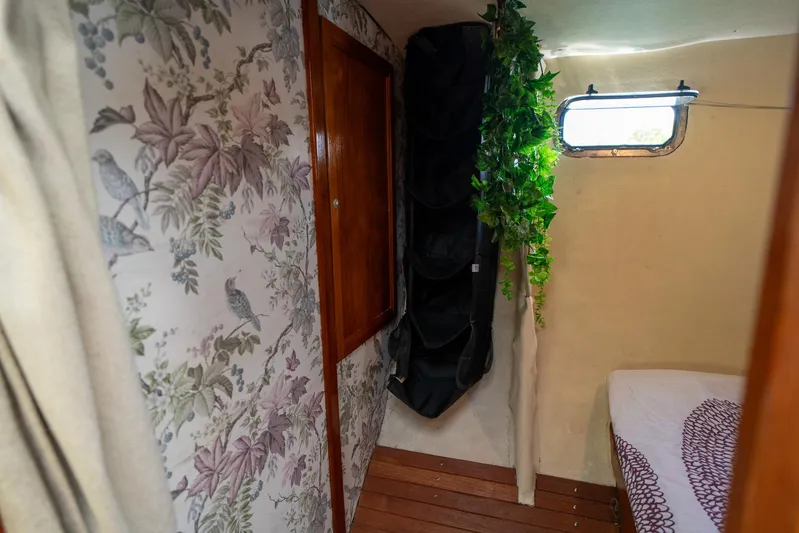 See The World Yacht Photos Pics Cozy cabin interior with floral wallpaper, wooden accents, and a small window.