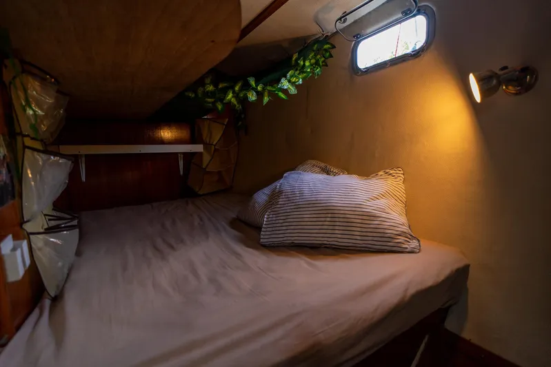 See The World Yacht Photos Pics Cozy boat cabin with striped pillows, soft lighting, and small window. Custom model 49, 1998.