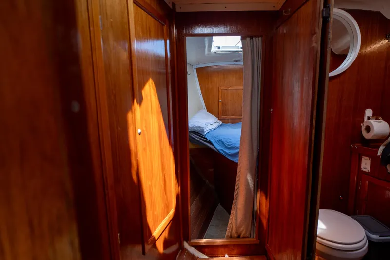 See The World Yacht Photos Pics Cozy wooden boat cabin interior with bed and bathroom, Custom 49, 1998 model.