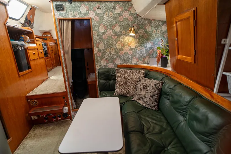 See The World Yacht Photos Pics Cozy boat interior with green leather seating, floral wallpaper, and wooden cabinetry, Custom 49, 1998.