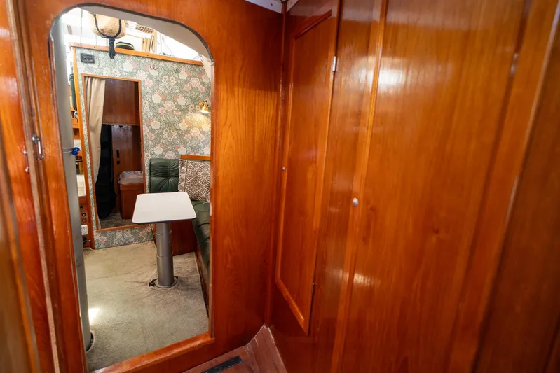 See The World Yacht Photos Pics Cozy wooden interior of a 1998 Custom 49 boat with floral wallpaper and seating area.