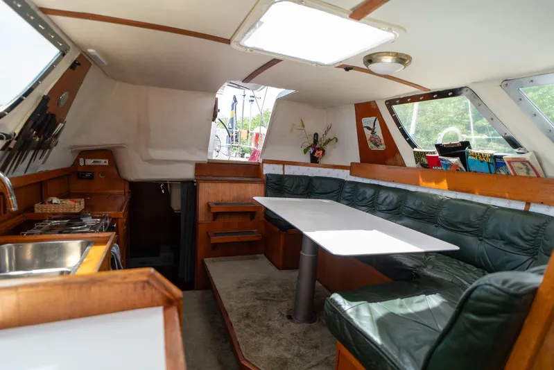 See The World Yacht Photos Pics Interior of a 1998 Custom 49 boat with kitchen and seating area.