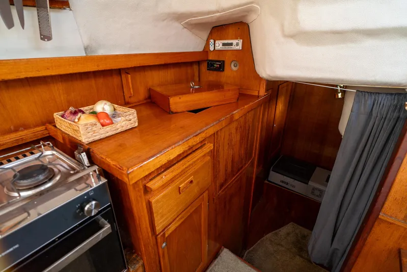 See The World Yacht Photos Pics Cozy wooden boat interior with stove, storage, and fruit basket, Custom model 49, 1998.