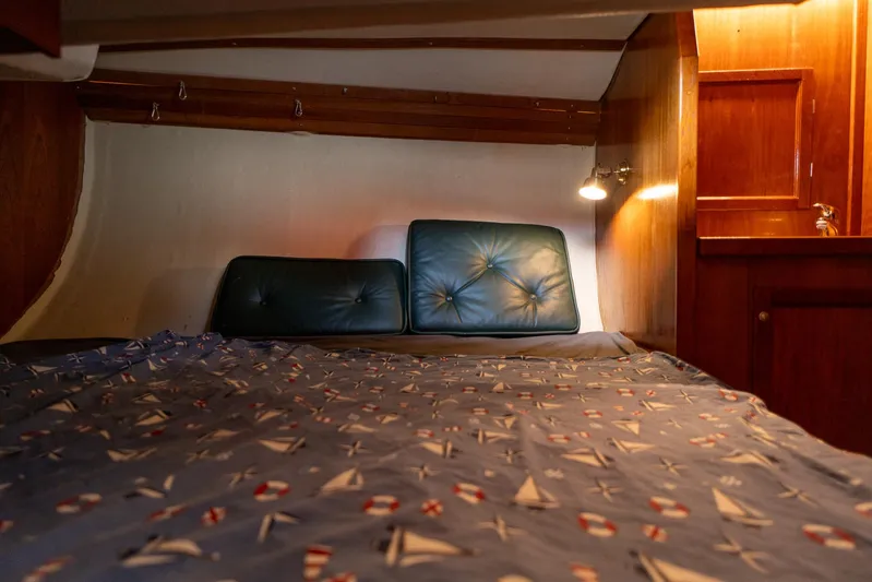 See The World Yacht Photos Pics Cozy boat cabin interior with nautical-themed bedding and warm wooden accents.