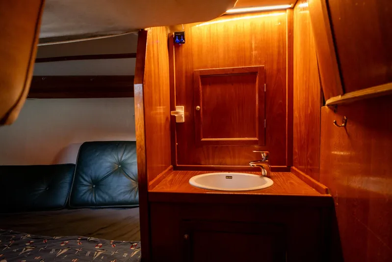See The World Yacht Photos Pics Wooden interior of a 1998 Custom 49 boat with sink and seating area.