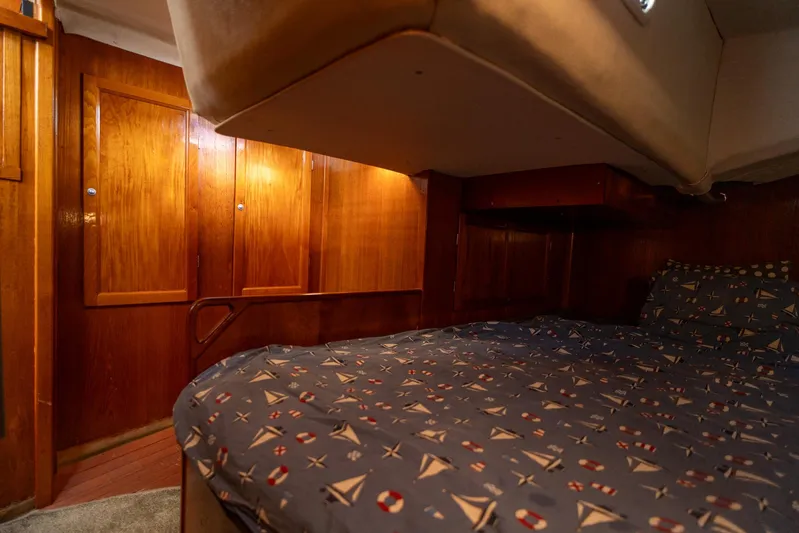 See The World Yacht Photos Pics Cozy wooden cabin interior with nautical-themed bedding, Custom model 49, 1998.