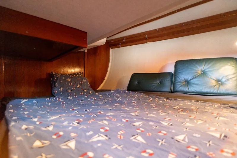 See The World Yacht Photos Pics Cozy boat cabin with nautical-themed bedding and cushioned headboard, Custom 49, 1998 model.