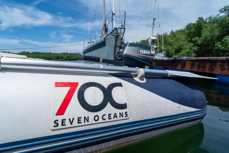 See The World Yacht Photos Pics Inflatable boat with "Seven Oceans" logo, docked near other vessels, under a clear blue sky.