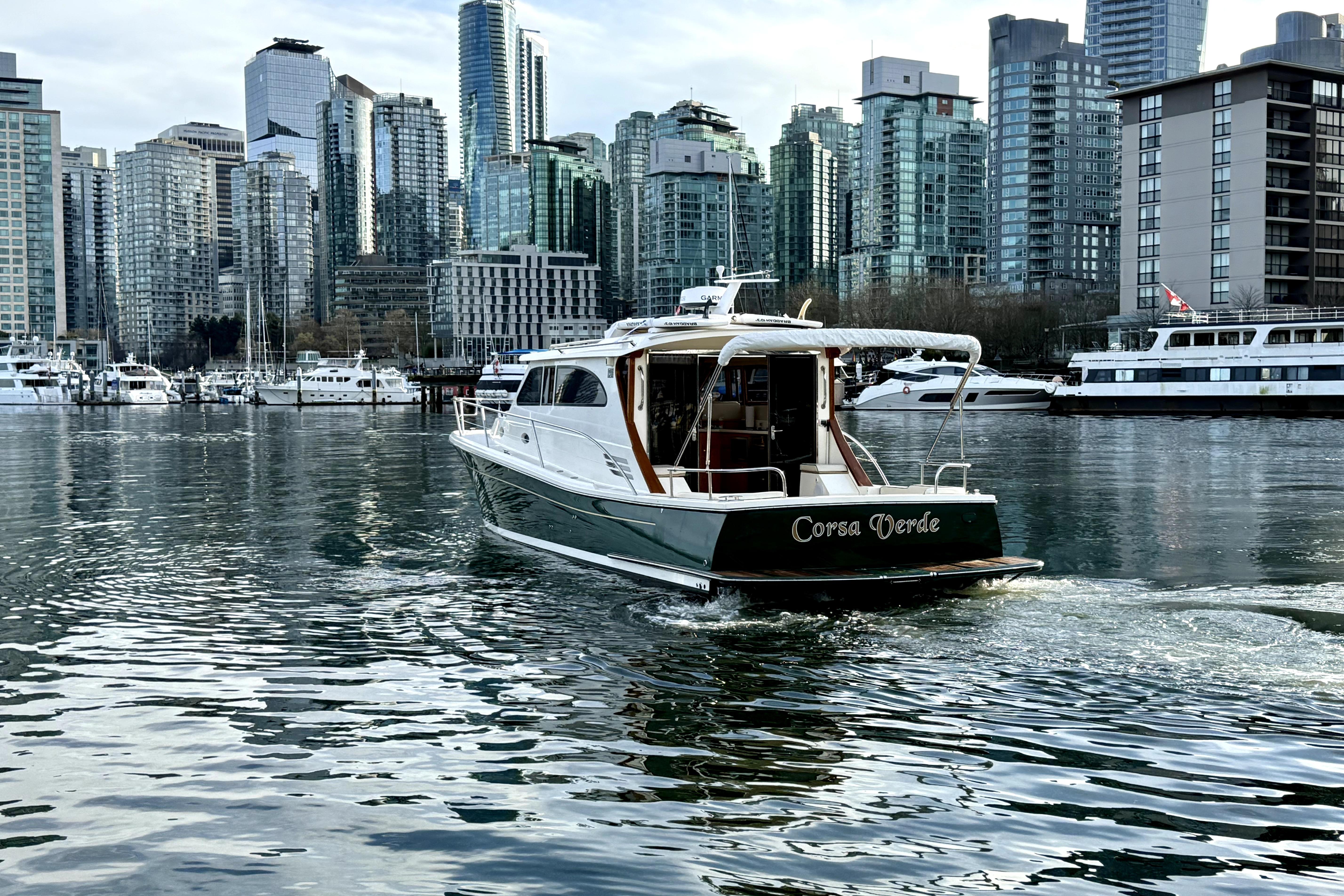 Rivolta Coupe 4.5 boat cruising in urban harbor with city skyline, 2012 model.