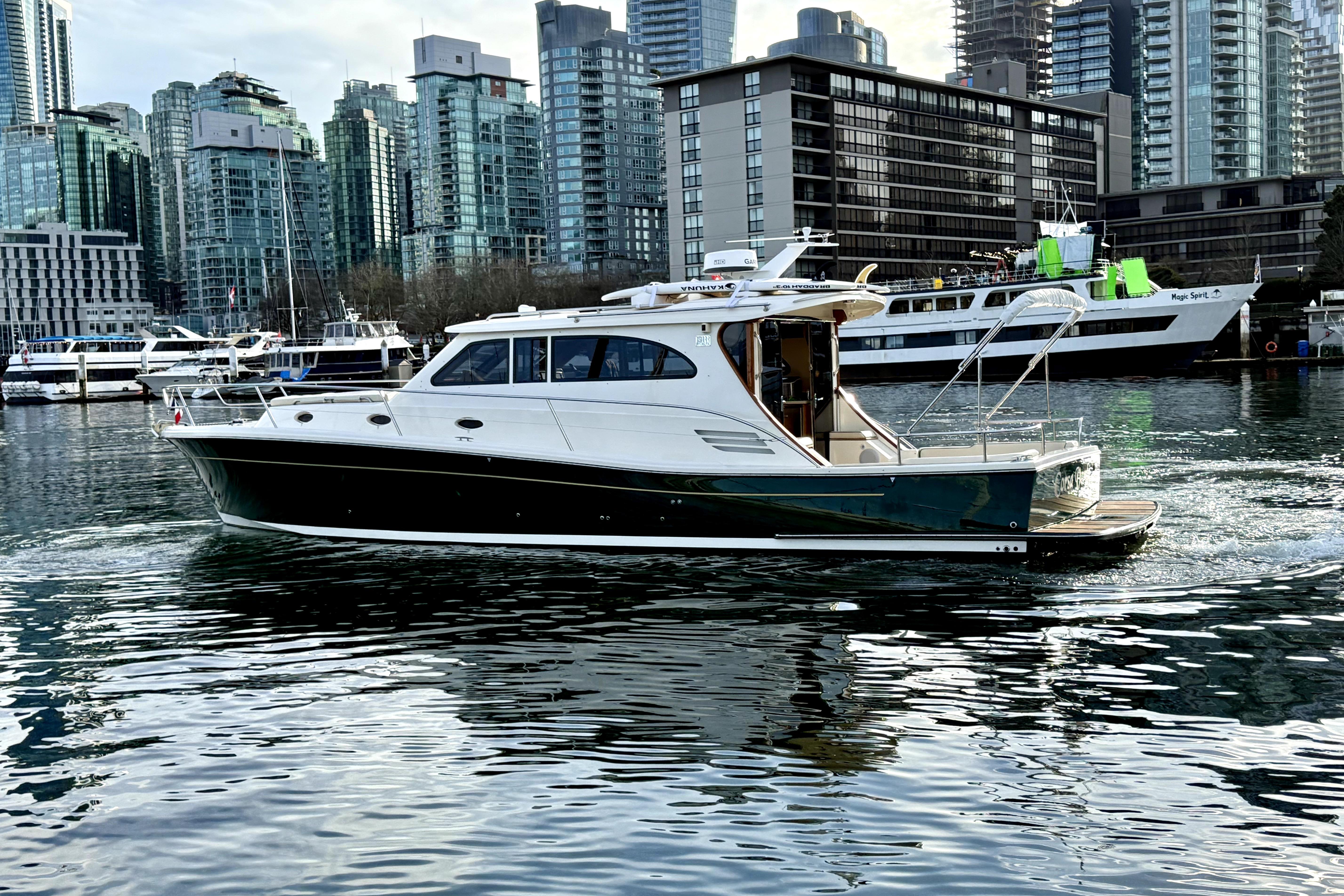 Rivolta Coupe 4.5 yacht cruising in urban marina, 2012 model, city skyline backdrop.