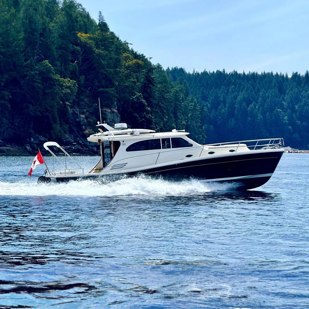 2012 Rivolta Coupe 4.5 boat cruising on a scenic lake with forested background.