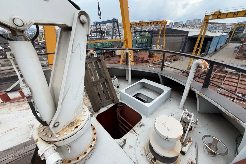 Soyaslan Custom Made Yacht Photos Pics Industrial shipyard scene with Soyaslan Custom 2027 vessel components and cranes in the background.