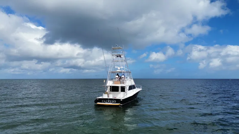 Calypso Yacht Photos Pics A 1996 Viking 47 Convertible boat named "Calypso" on open water under cloudy skies.
