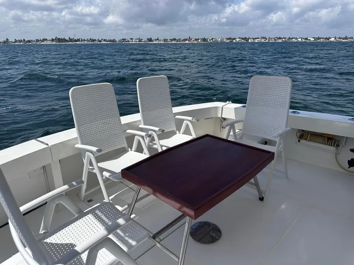 Calypso Yacht Photos Pics Deck of 1996 Viking 47 Convertible yacht with chairs and table, overlooking the ocean.