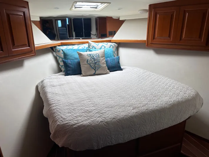 Calypso Yacht Photos Pics Cozy bedroom in 1996 Viking 47 Convertible yacht with elegant bedding and wooden cabinets.
