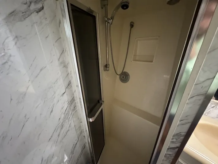 Calypso Yacht Photos Pics Shower area in 1996 Viking 47 Convertible yacht with marble walls and sliding door.