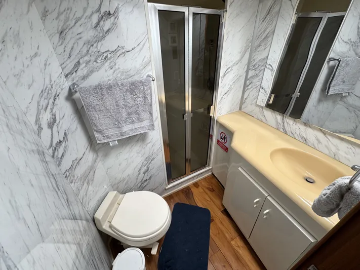 Calypso Yacht Photos Pics Bathroom interior of 1996 Viking 47 Convertible yacht with marble walls and compact design.