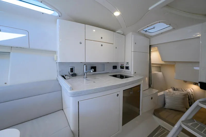  Yacht Photos Pics Luxurious interior of 2020 Intrepid 407 Cuddy boat with modern kitchen and seating area.