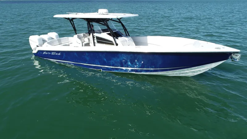  Yacht Photos Pics 2022 Nor-Tech 340 Sport Center Console boat on calm water, featuring a sleek blue design.
