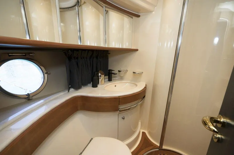  Yacht Photos Pics Luxurious bathroom interior of 2005 Azimut 68 yacht with porthole and modern fixtures.
