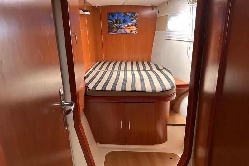  Yacht Photos Pics 2011 Robertson & Caine Leopard 46 cabin interior with striped bedding and wooden finish.