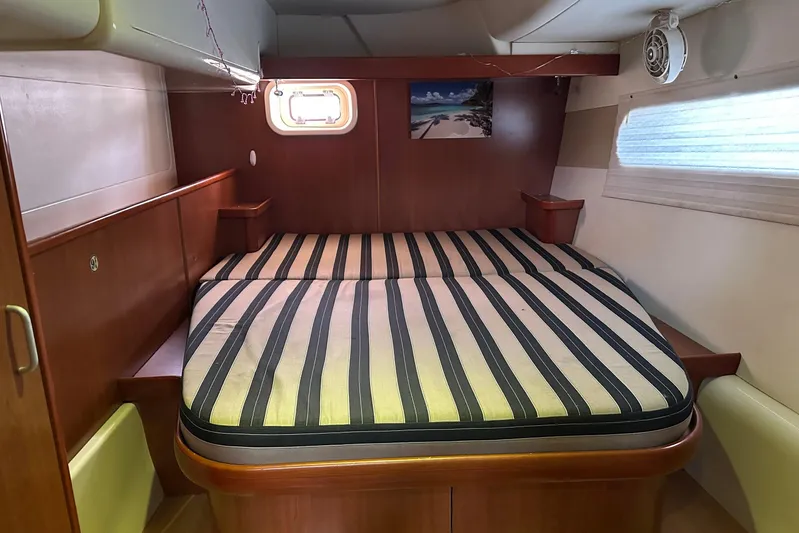  Yacht Photos Pics 2011 Robertson & Caine Leopard 46 yacht cabin with striped bedding and wooden interior.