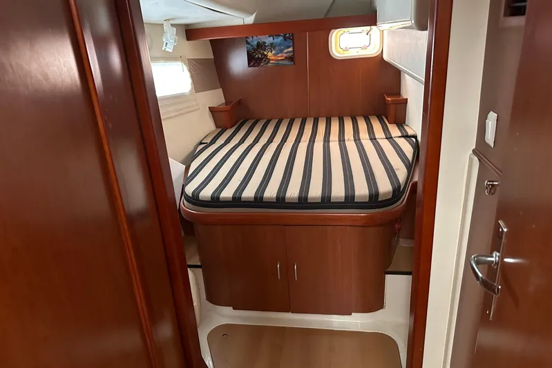  Yacht Photos Pics Cozy cabin interior of 2011 Robertson & Caine Leopard 46 yacht with striped bedding.
