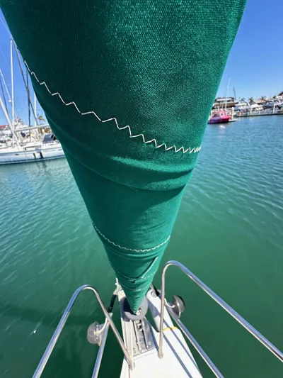 Ma Jolie Yacht Photos Pics Close-up of a green sail on a 1996 J Boats J/120 in a marina.