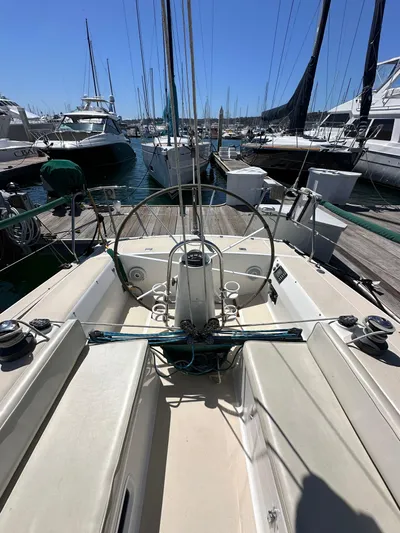 Ma Jolie Yacht Photos Pics 1996 J Boats J/120 sailboat docked in a marina, showcasing cockpit and steering wheel.