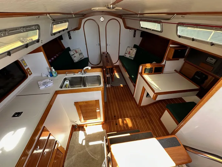 Ma Jolie Yacht Photos Pics Interior of a 1996 J Boats J/120 sailboat, featuring a cozy cabin with wood finishes.