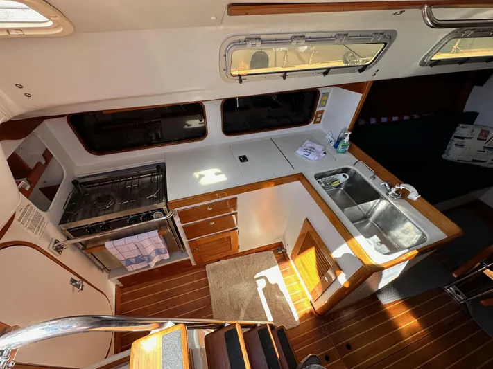 Ma Jolie Yacht Photos Pics Interior of 1996 J Boats J/120 yacht, featuring a compact kitchen with stove and sink.