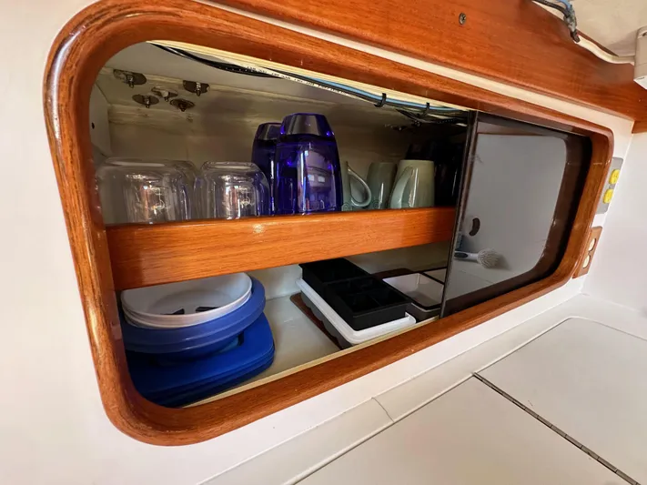 Ma Jolie Yacht Photos Pics Cabinet interior of 1996 J Boats J/120 yacht with glassware and kitchen items.