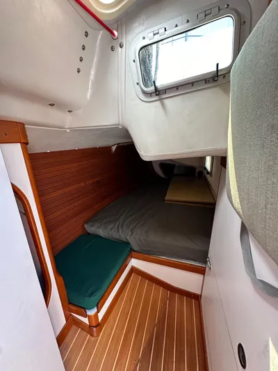 Ma Jolie Yacht Photos Pics 1996 J Boats J/120 cabin interior with wooden flooring and cozy sleeping area.