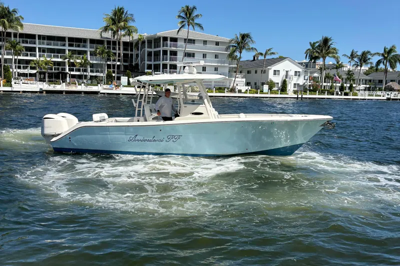 Joe Yacht Photos Pics 2018 Cobia 301 Center Console boat cruising near waterfront homes and palm trees.