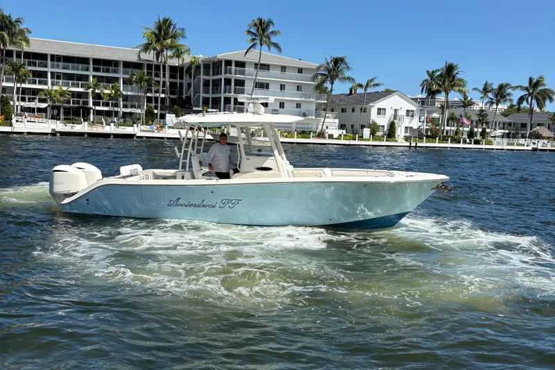 Joe Yacht Photos Pics 2018 Cobia 301 Center Console boat cruising near waterfront homes and palm trees.