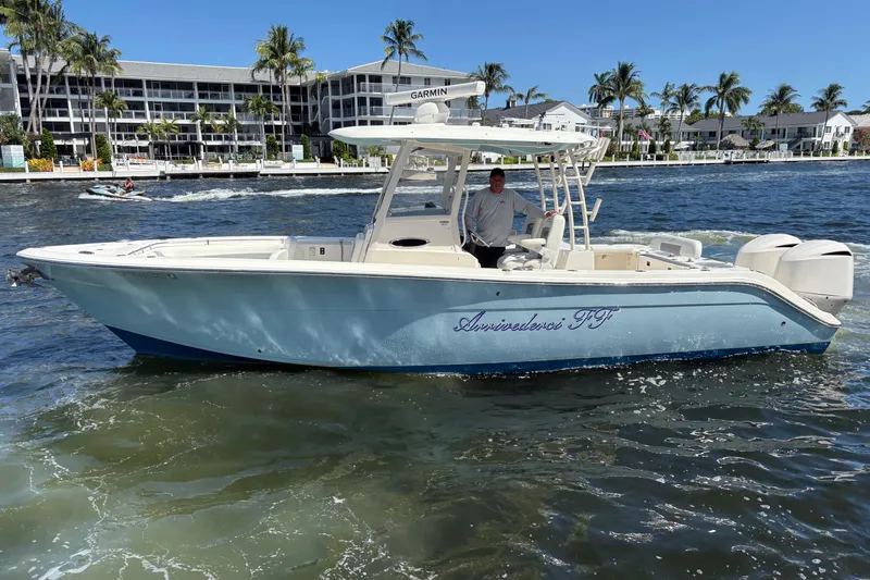 Joe Yacht Photos Pics 2018 Cobia 301 Center Console boat on water, with palm trees and buildings in background.