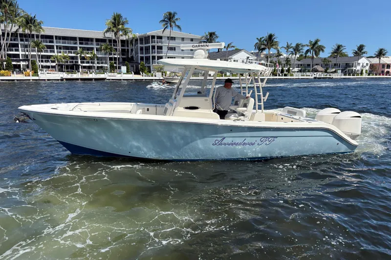 Joe Yacht Photos Pics 2018 Cobia 301 Center Console boat cruising on a sunny day near waterfront buildings.