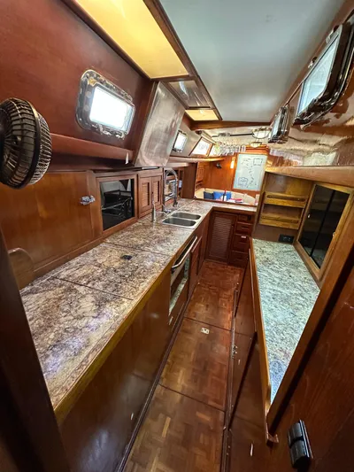 Unexpected Pleasure Yacht Photos Pics 1985 Nautical Development 56 yacht interior with wooden cabinetry and granite countertops.