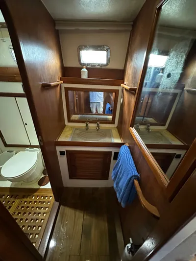 Unexpected Pleasure Yacht Photos Pics 1985 Nautical Development 56 yacht bathroom with wooden cabinetry and mirror.