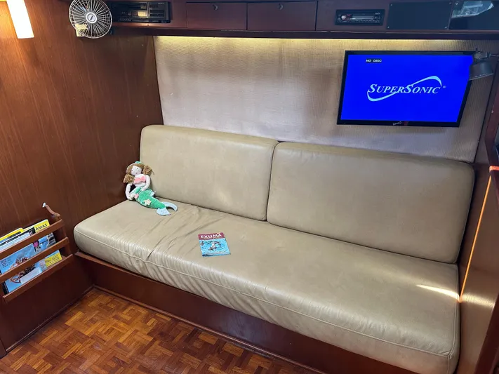 Unexpected Pleasure Yacht Photos Pics Cozy interior of 1985 Nautical Development 56 yacht with sofa, TV, and decor.