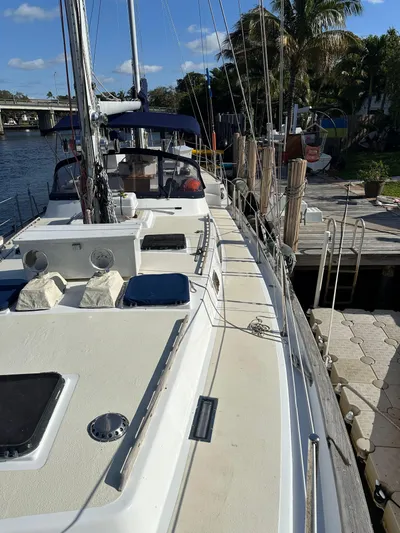 Unexpected Pleasure Yacht Photos Pics 1985 Nautical Development 56 sailboat docked by a sunny waterfront.
