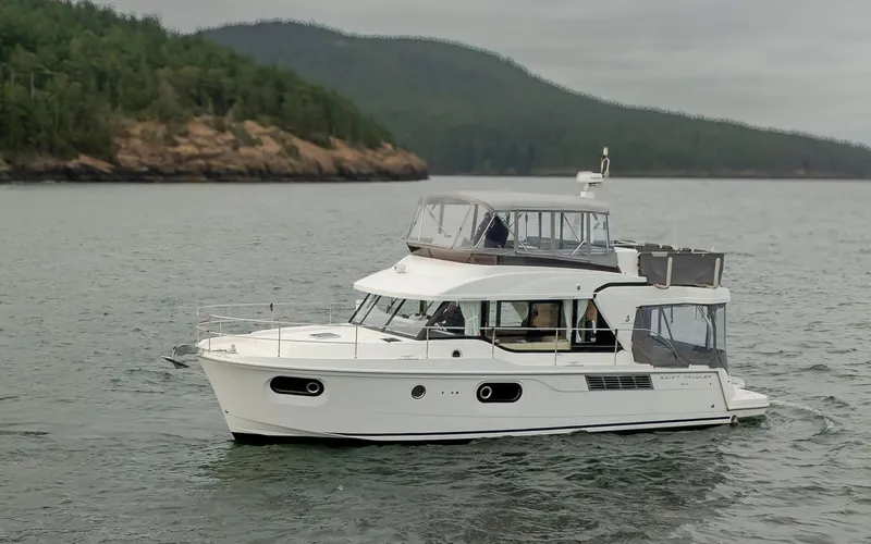 4 My Valentine Yacht Photos Pics 2022 Beneteau Swift Trawler 41 cruising on a scenic lake with forested hills.