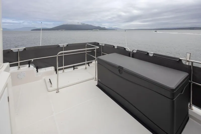 4 My Valentine Yacht Photos Pics 2022 Beneteau Swift Trawler 41 deck with storage box, overlooking calm waters.