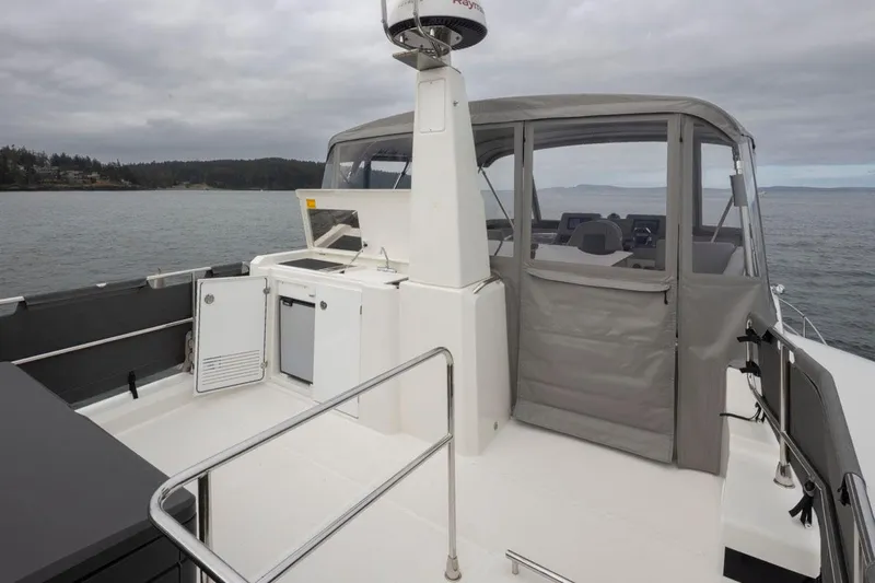 4 My Valentine Yacht Photos Pics 2022 Beneteau Swift Trawler 41 with outdoor kitchenette and enclosed cockpit on calm waters.